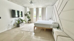 A modern bedroom with a bed, a TV, and potted plants. - Paradise apartment 2 bedroom / 2 Baths with parking in vibrant Miami (Miami)