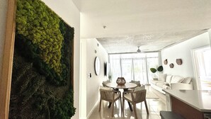 A modern interior with a dining area, a sofa, and a wall with a vertical garden. - Paradise apartment 2 bedroom / 2 Baths with parking in vibrant Miami (Miami)