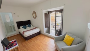 Une chambre à coucher avec un lit, une fenêtre, un canapé et une salle de bain.