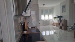 A modern kitchen with a black countertop, a sink, and a window with curtains. - Casa Adelaide close to MM3 Family sized new apartment (Milano)