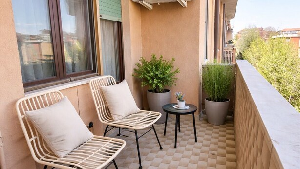 A balcony with two wicker chairs, a small table, and a potted plant. - Casa Adelaide close to MM3 Family sized new apartment (Milano)