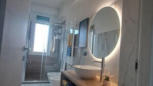 A modern bathroom with a large mirror, a sink, and a shower area. - Casa Adelaide close to MM3 Family sized new apartment (Milano)
