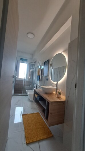 A modern bathroom with a large mirror, a sink, and a shower area. - Casa Adelaide close to MM3 Family sized new apartment (Milano)