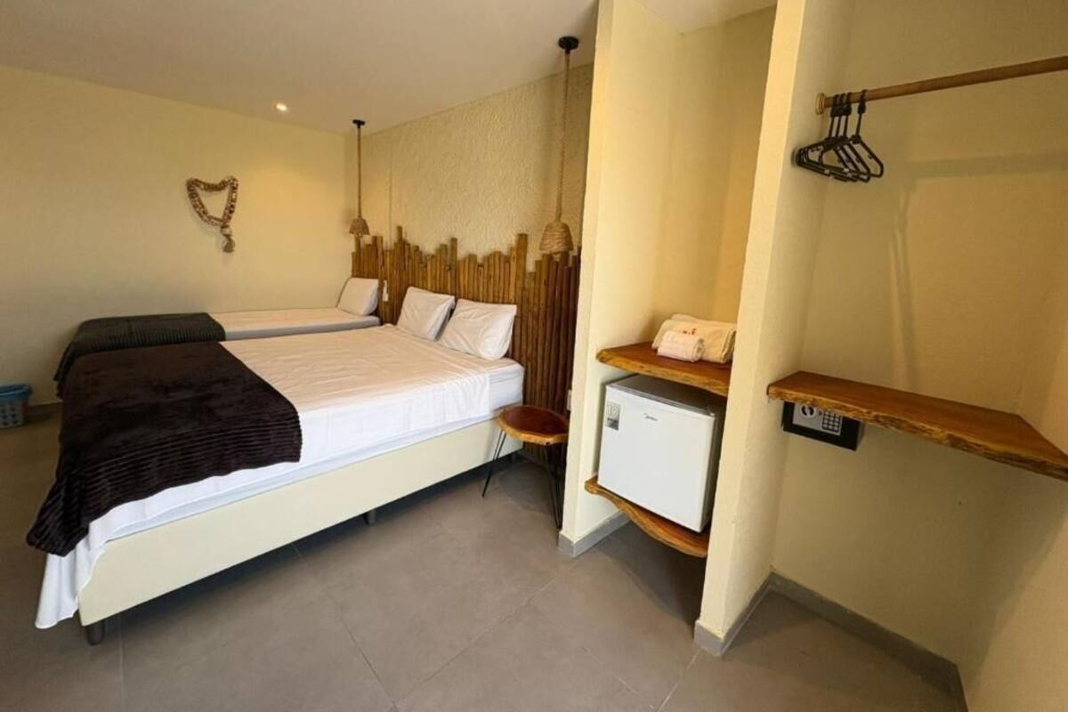 Ein Schlafzimmer mit einem Bett, einem Nachttisch und einem kleinen, weißen Kühlschrank.