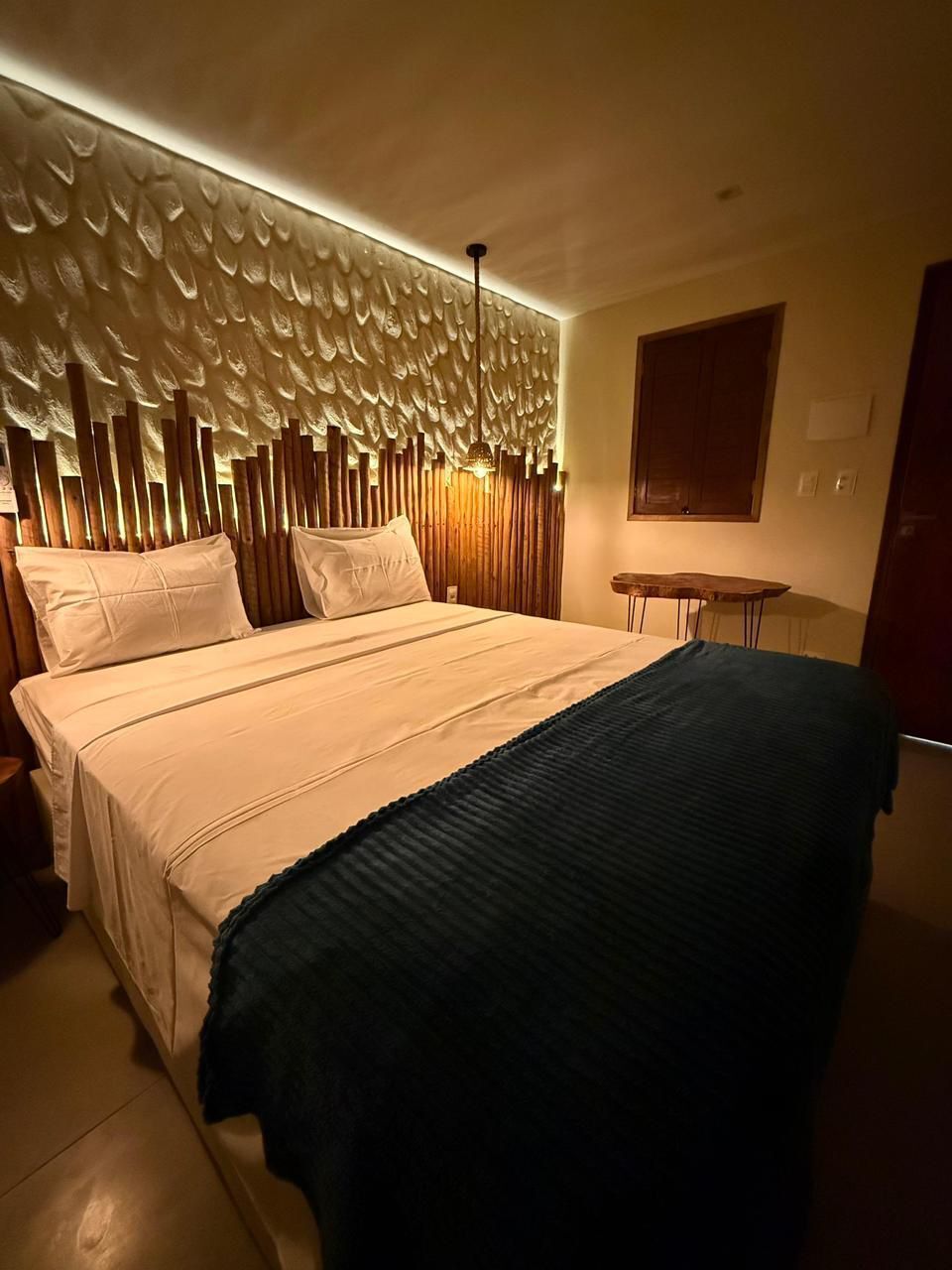 Ein Hotelzimmer mit einem Bett, einem kleinen Tisch und einem Holzkopfteil.