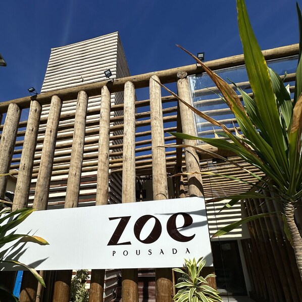 A building with a sign reading 'ZOE POUSA DA' and a bamboo fence. - Zoe Pousada (Ipojuca)