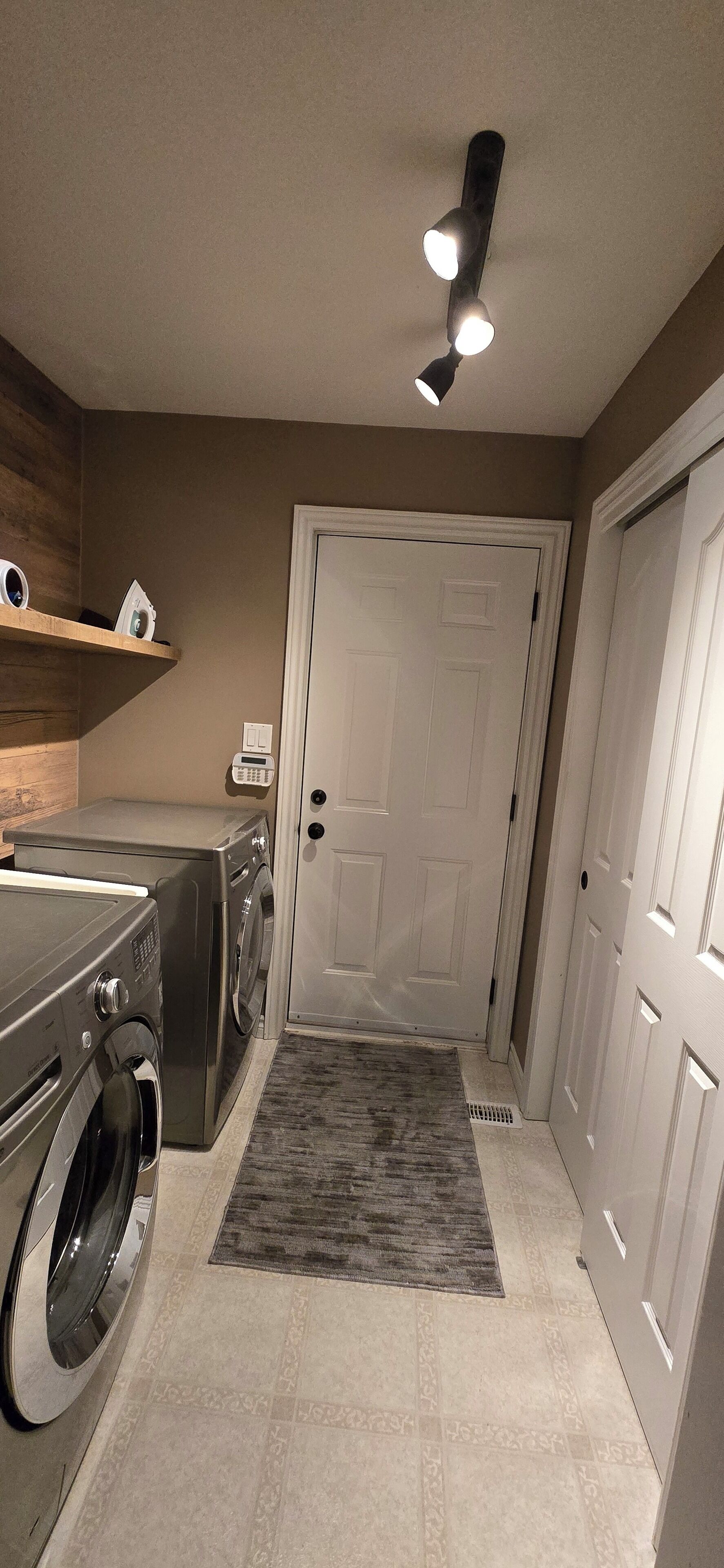 A laundry room with a washing machine, dryer, and a ceiling light fixture.
