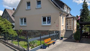 A two-story building with a stone facade, a front entrance with steps, and a bench in the foreground. - Quietly situated in the Lahn-Dill mountains (Bad Endbach)