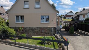 A two-story house with a stone foundation and a beige upper floor. - Quietly situated in the Lahn-Dill mountains (Bad Endbach)