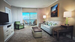 A hotel room with a balcony, a television, a sofa, a coffee table, and a lamp. - Marriott OceanWatch 2-bedroom villa in Myrtle Beach, SC (Myrtle Beach)