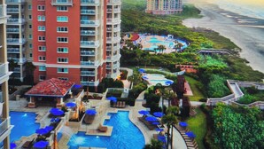 A resort with a large swimming pool, multiple lounge areas, and a beachfront view. - Marriott OceanWatch 2-bedroom villa in Myrtle Beach, SC (Myrtle Beach)