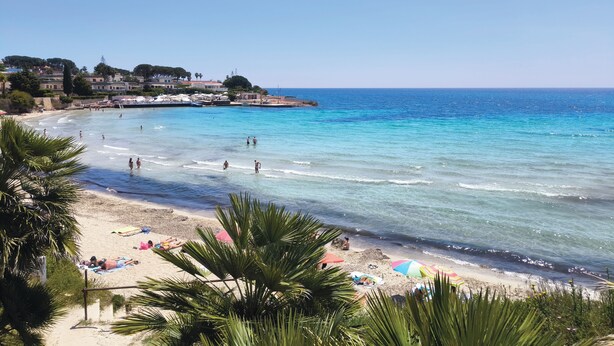 A beach with clear blue water, people swimming and sunbathing, and buildings in the background. - An exclusive, quiet home and the terrace of your dreams in the heart of Noto (Noto)