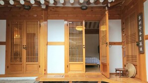Una habitación tradicional japonesa con suelo de tatami, puertas correderas y techo de madera con celosías shoji.
