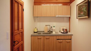 Una pequeña cocina con armarios de madera, un lavamanos y una encimera.