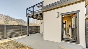 Uma casa moderna com varanda coberta, porta de garagem e vista para montanhas.