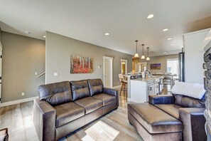 A modern living room with a leather sofa, a dining area, and a kitchen in the background. - Buena Vista Downtown Retreat STR-309 (Buena Vista)