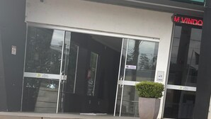Η εξωτερική όψη του ξενοδοχείου Zagonel, με μια μεγάλη γυάλινη είσοδο και μια φωτεινή επιγραφή νέον που αναγράφει «M Vindo».
