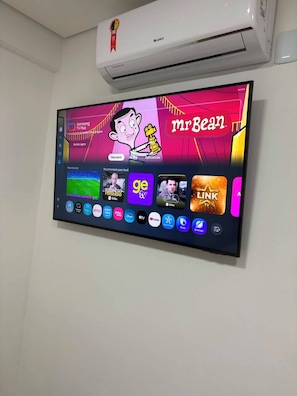 Ein Flachbildfernseher an der Wand, mit einer Auswahl an Streaming-Apps und einer Zeichentrickfigur.