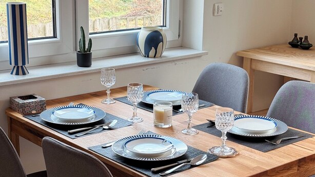 A dining area with a wooden table set for four, surrounded by chairs. - Large, cozy vacation apartment in the heart of the Kraichgau. (Kraichtal)