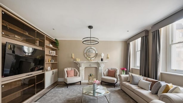 A living room with a fireplace, sofas, a coffee table, and a TV.