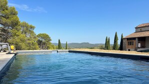 A swimming pool with a view of trees and mountains in the background. - Mas Grange Neuve (Potelières)