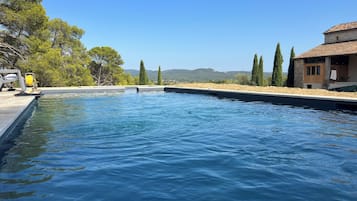 Een seizoensgebonden buitenzwembad, parasols voor strand/zwembad