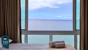 Ett hotellrum med ett stort fönster som ger utsikt över havet.