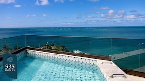 A pool with a glass railing overlooking the ocean. - Experience Barra’s waterfront with a wide sea view (Salvador)