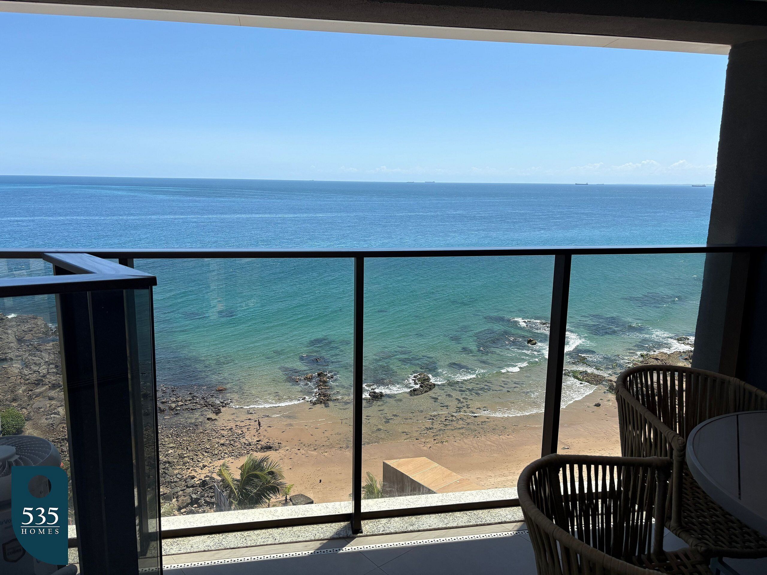 Ein Balkon mit Blick auf den Ozean, einen Strand und ein Schild mit der Aufschrift 535 Häuser.