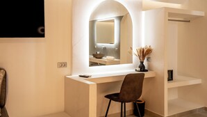Un baño moderno con tocador, espejo y una silla.