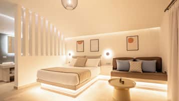 Ein modernes Schlafzimmer mit Bett, Sofa, Nachttischen und Wandleuchten.
