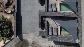 Un área de piscina en la azotea con varios sillones de sol y un camino de piedra.
