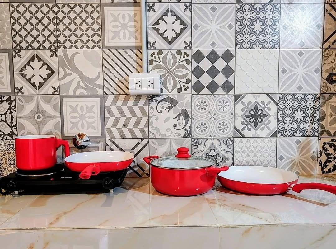 Een keuken met een betegelde spatwand met diverse geometrische en bloemmotieven.