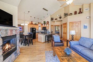 Ein geräumiges Wohnzimmer mit Kamin, einem blauen Sofa und einem Holztisch.