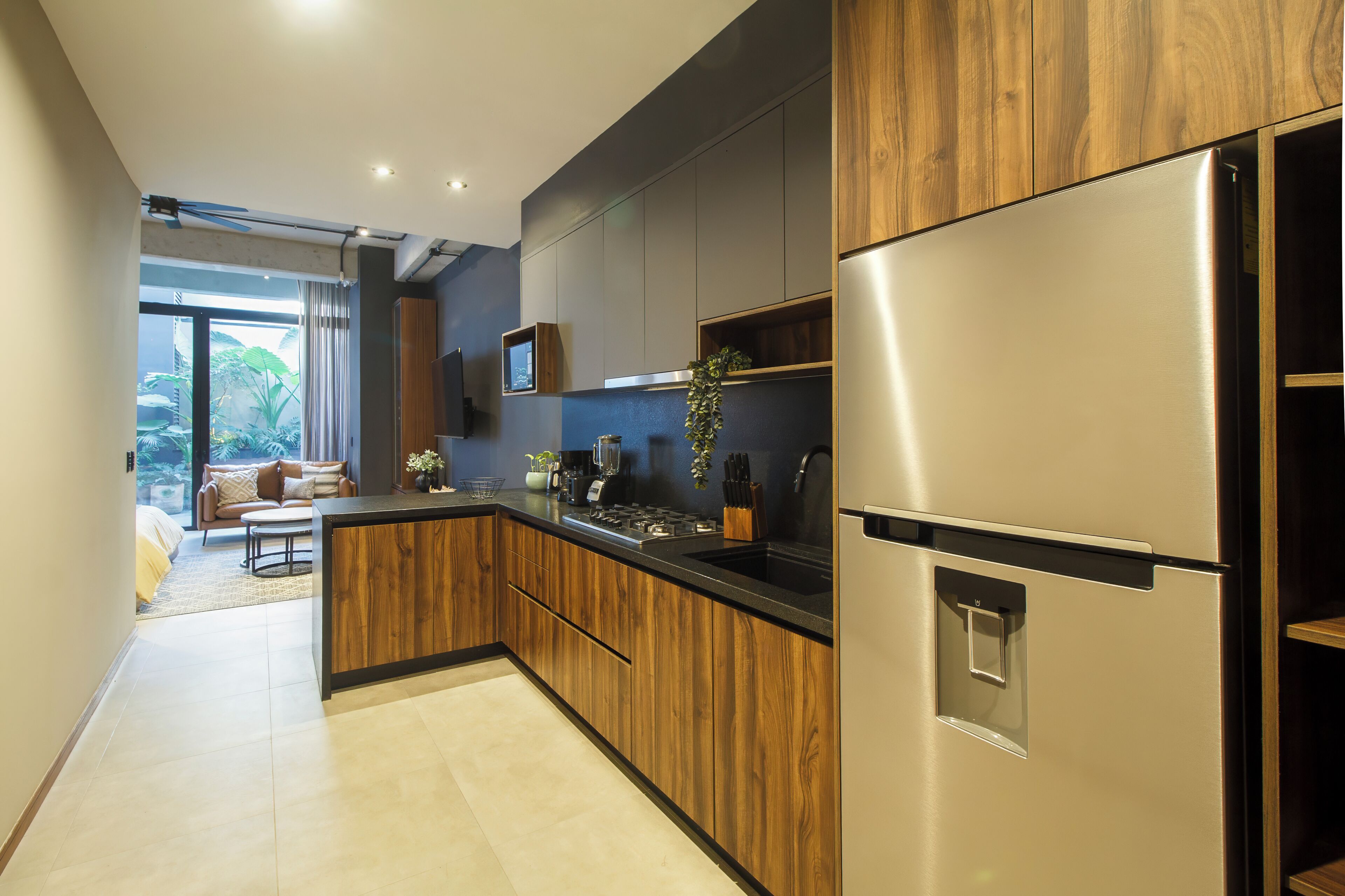 Une cuisine moderne avec des meubles en bois, un réfrigérateur en acier inoxydable et un four encastré.