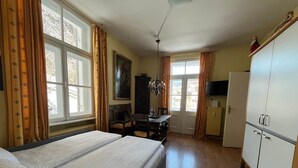 A room with a bed, a desk, a chair, a television, and a wardrobe. - Vacation apartment Alpenglühen - Untersberg view (Berchtesgaden)