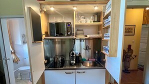 A compact kitchen with a microwave, stove, and various utensils. - Vacation apartment Alpenglühen - Untersberg view (Berchtesgaden)