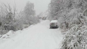 A snow-covered road with a vehicle in the distance. - Kabila King Resort (Chakrata)