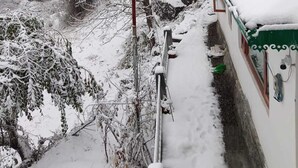 A snowy landscape with a building featuring a green roof and white walls. - Kabila King Resort (Chakrata)