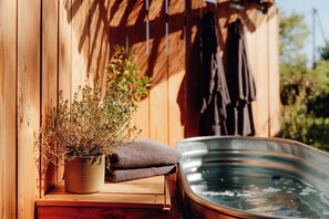 A wooden sauna with a hot tub, a potted plant, and a towel on a wooden bench. - Le Clos des Pies, "Le Cocon" double room, with Nordic bath in the heart of nature (Le Pin)
