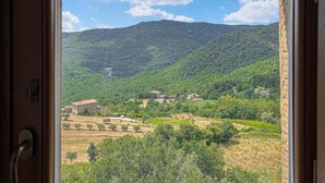 A view from a window overlooking a mountainous landscape with scattered buildings. - Tuscan Organic Farm House Alba Etrusca (cortona)