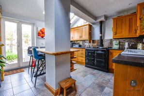 A modern kitchen with wooden cabinets, a black stove, and a tiled backsplash.