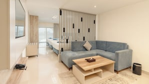 Un salon moderne avec un canapé, une table basse et un téléviseur.