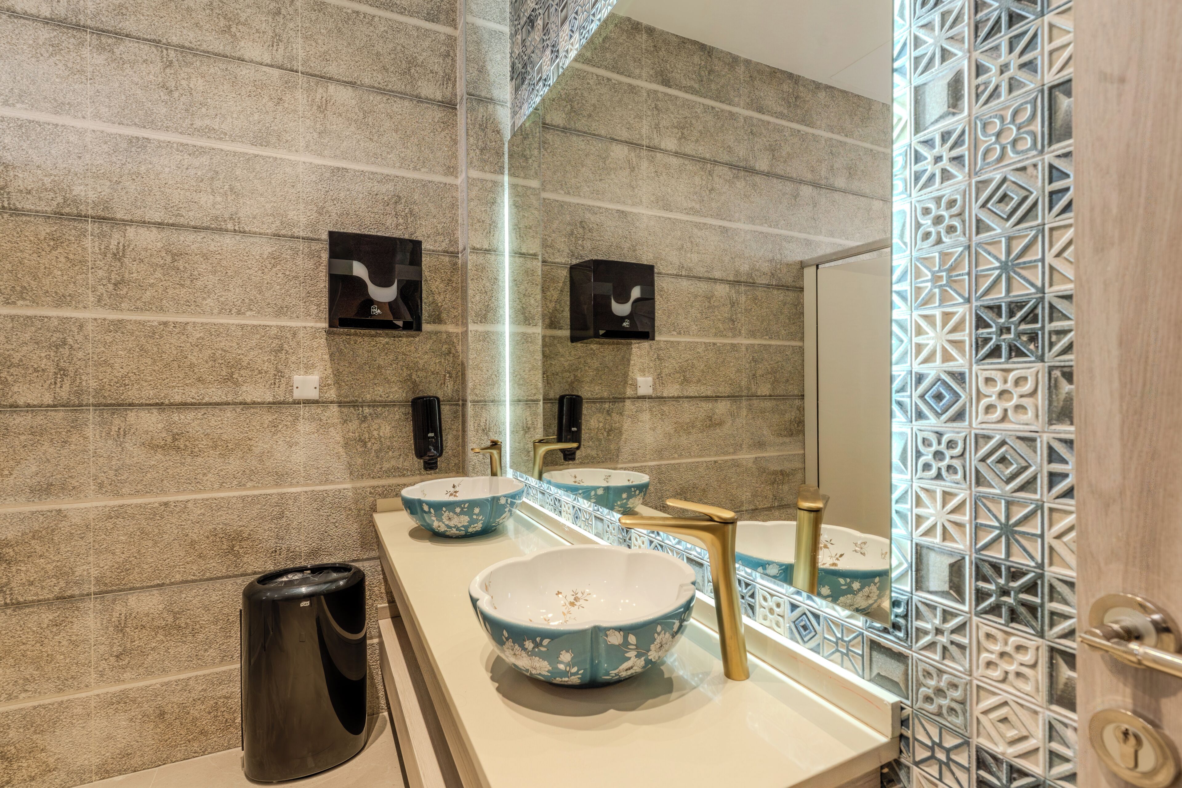 A bathroom with a long counter, two sinks, and a mirror.