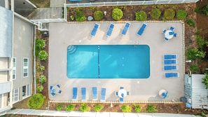 A rooftop swimming pool with lounge chairs and a table, surrounded by a garden with various plants. - A Place At The Beach II 1F Shore Drive- 2BR- Pool (Myrtle Beach)