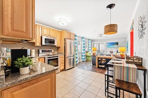 A modern kitchen with wooden cabinets, stainless steel appliances, and a tiled floor. - A Place At The Beach II 1F Shore Drive- 2BR- Pool (Myrtle Beach)