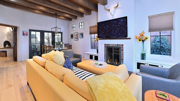 Una sala de estar moderna con sofá, chimenea, televisor y obras de arte.