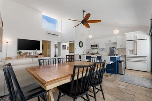 Una cocina moderna con armarios blancos, microondas y refrigerador.
