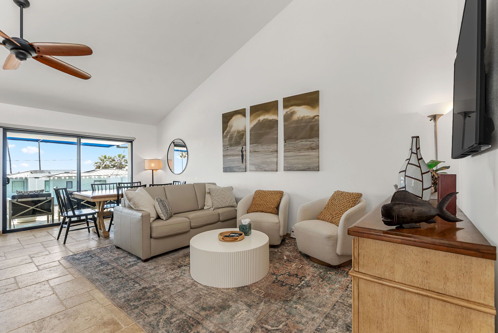 Ein modernes Wohnzimmer mit einer Couch, Sesseln, einem Couchtisch und Kunstwerken an der Wand.