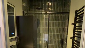 A bathroom with a glass shower enclosure, a white sink, and a black towel rack. - Appartement Racine (Appart. 1) on garden with fireplace (Villers-Cotterêts)
